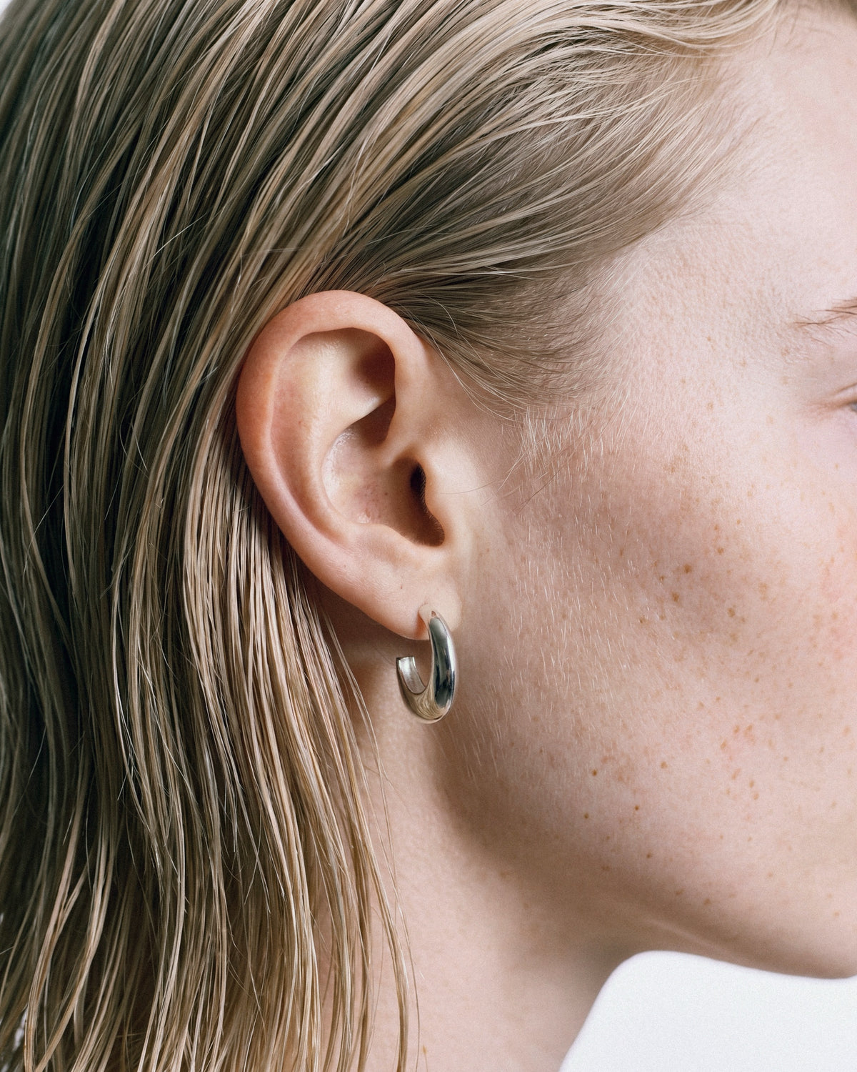 SAGA Anchor Hoops in Silver, worn by a model – close-up, for COLD SKIN.