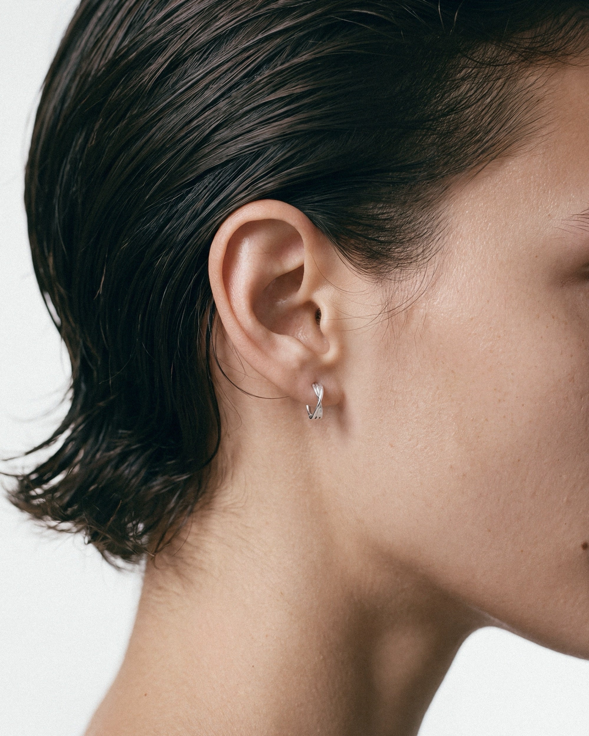 Baixa Eli Hoops in silver, worn by a model — close-up, for COLD SKIN.
