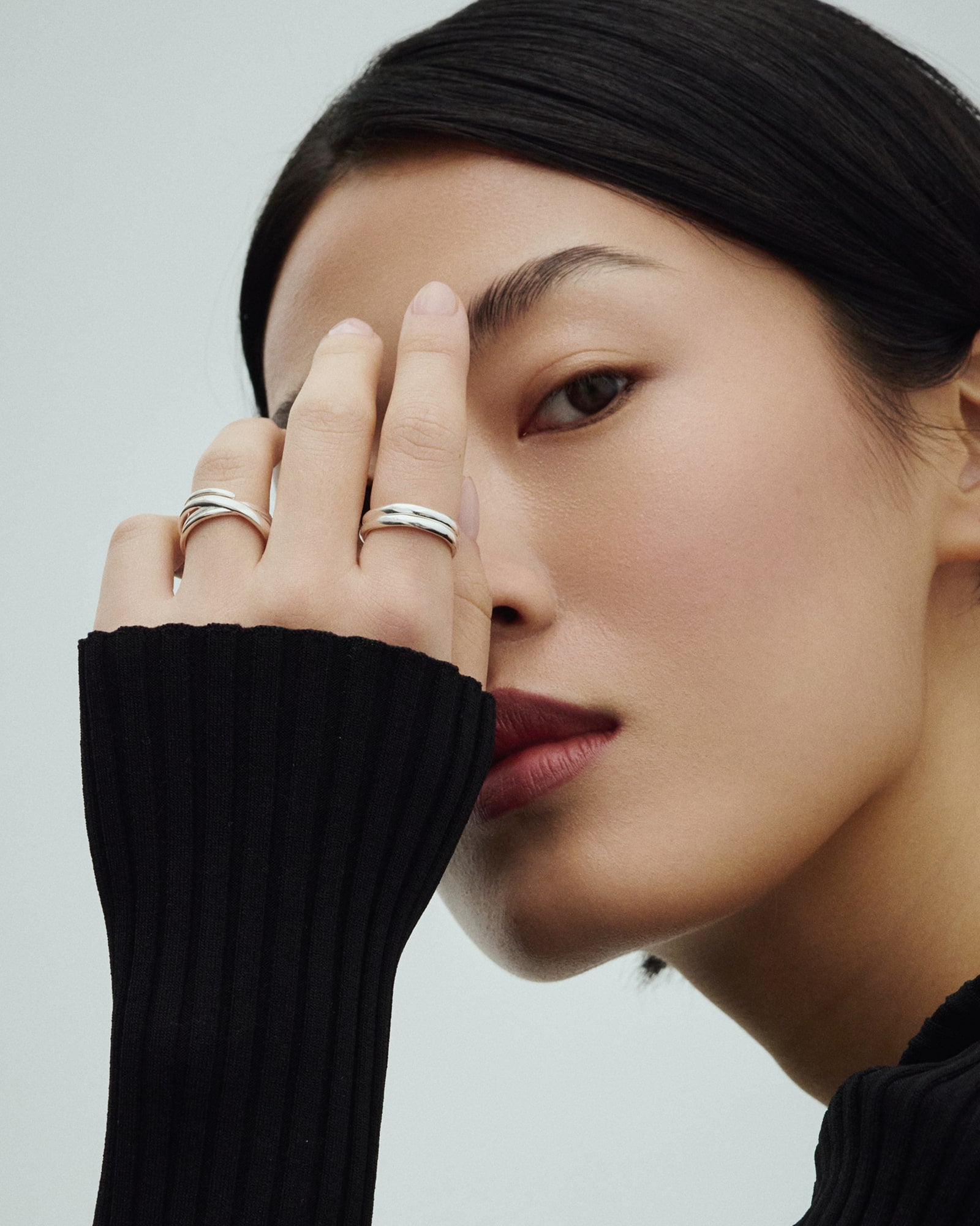 Female model wearing Arishi Basic Small Rings and Baixa Ana Ring in silver.