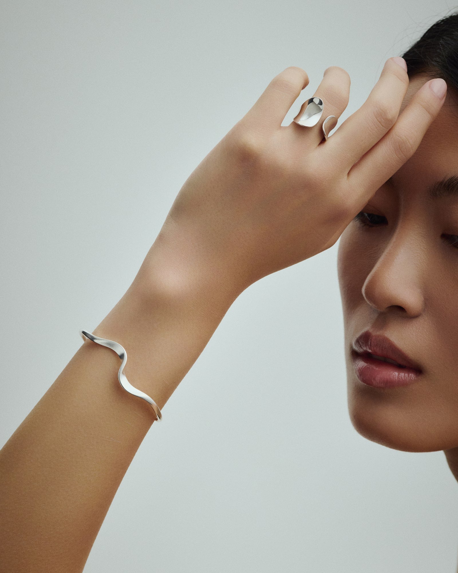 Female model wearing Baixa Alessa Ring and Juna Bracelet in Silver for COLD SKIN.