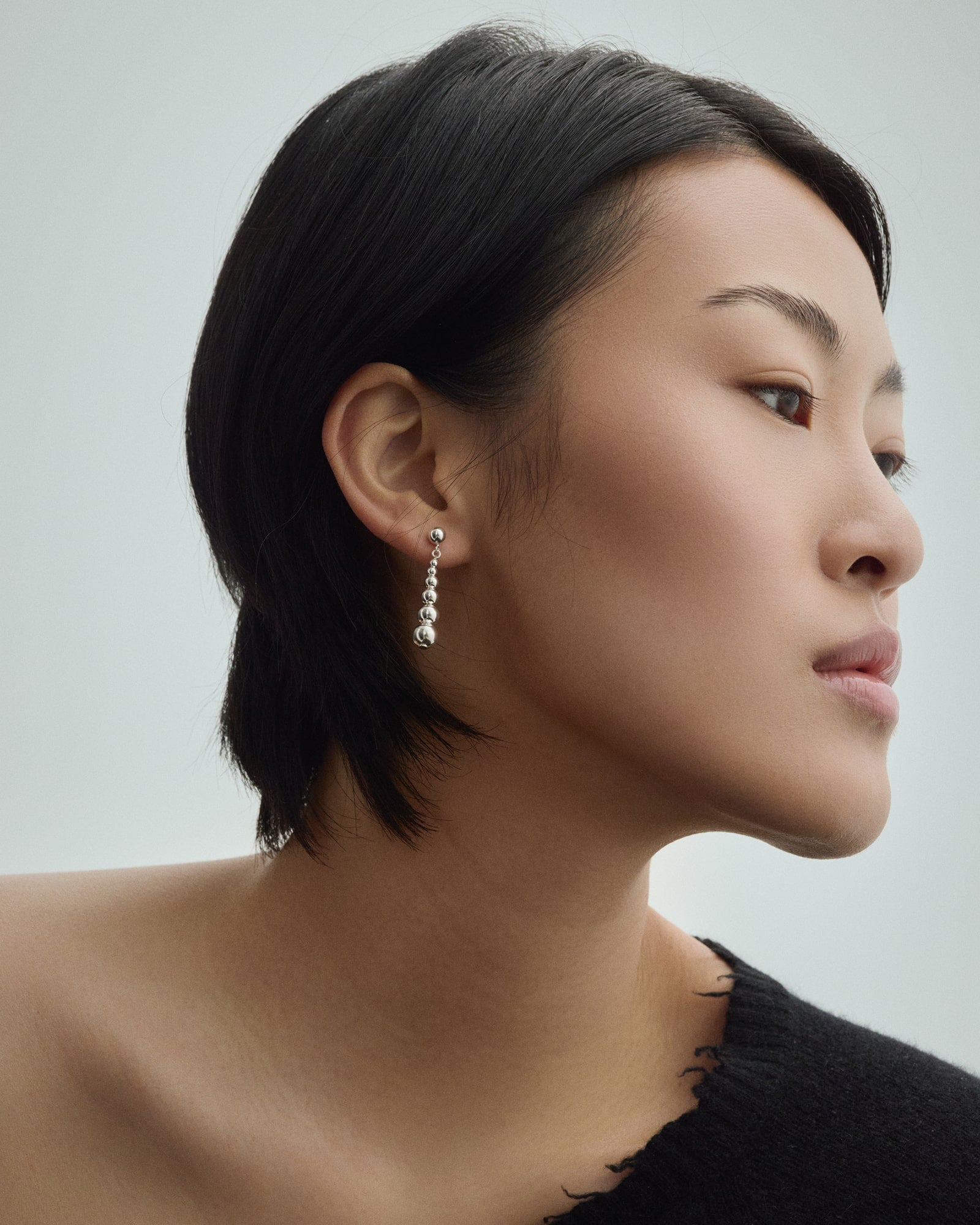 Female model wearing Baixa Juno Earrings in silver for COLD SKIN.