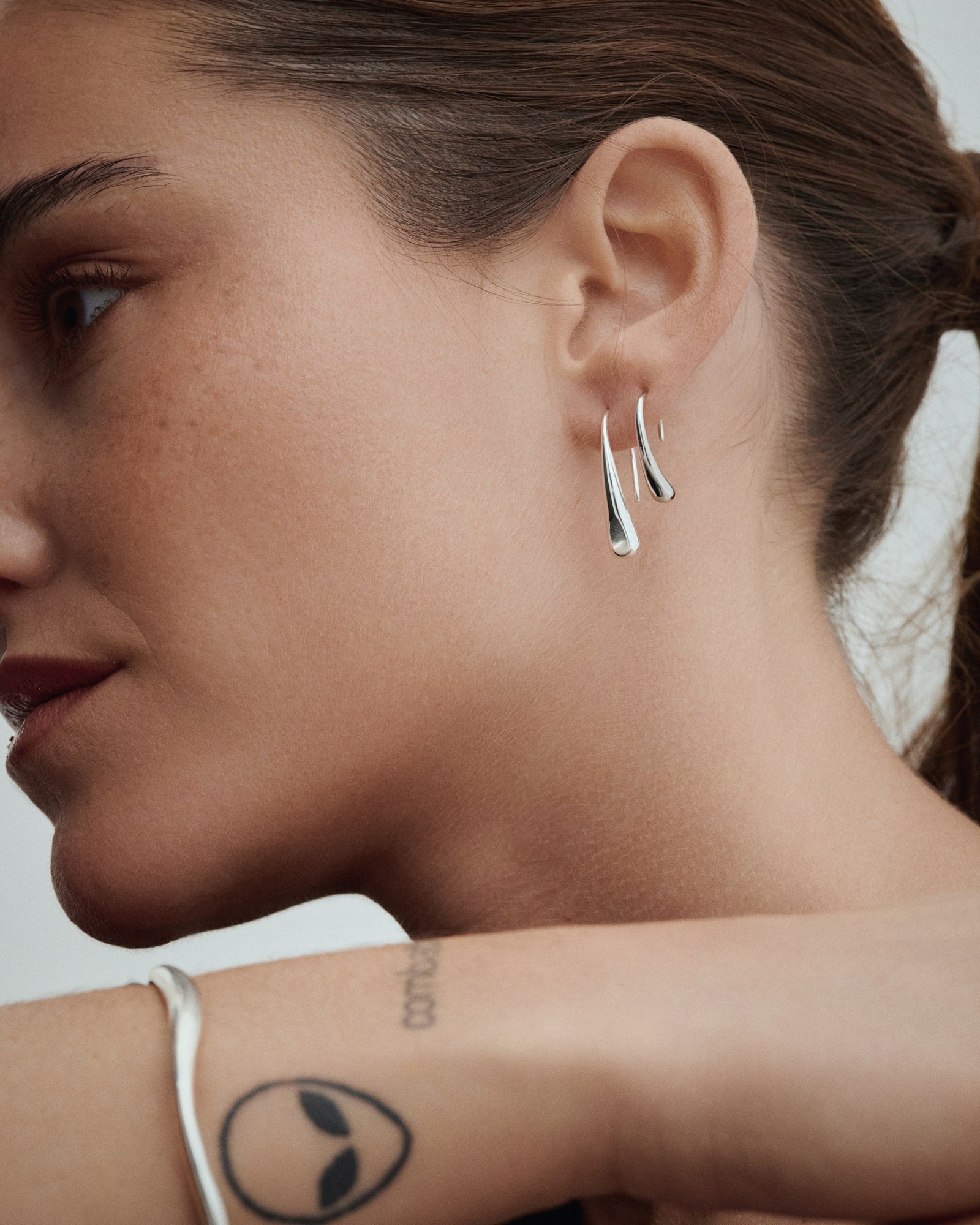 Female model wearing Baixa Maya Hoops Big and Maya Hoops Small in silver.