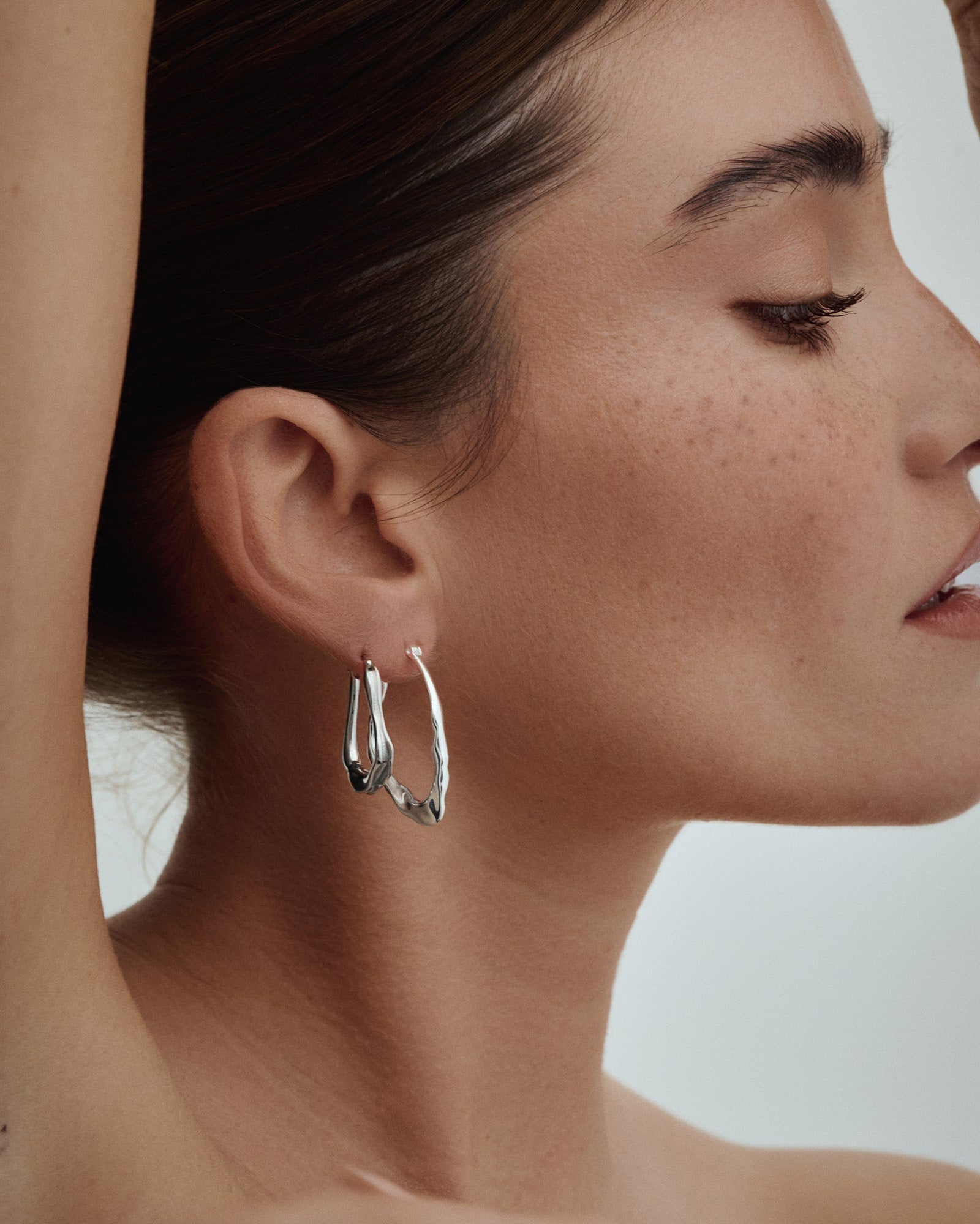 Female model wearing Baixa Mia Earrings and Dalia Hoops in Silver.