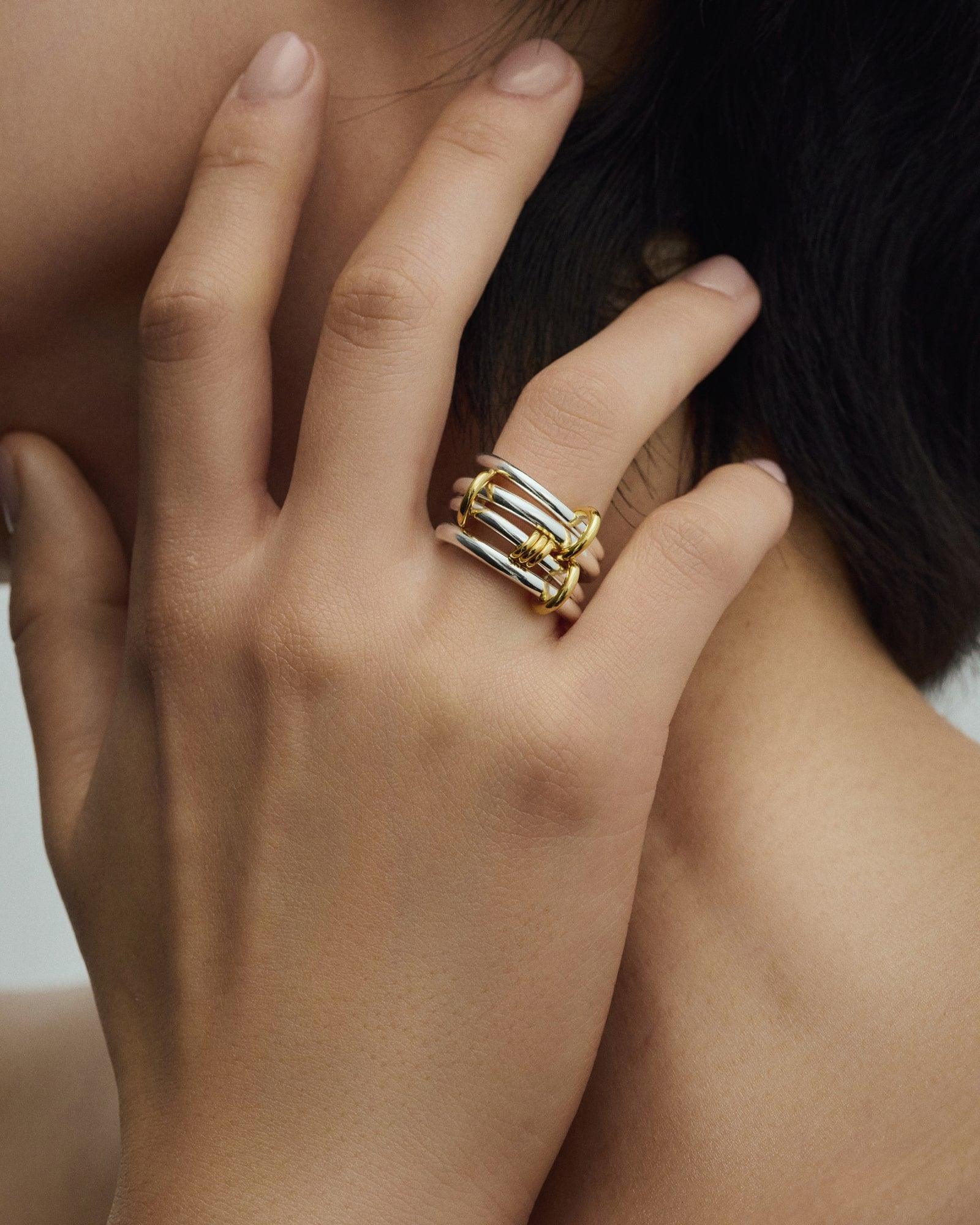 Female model wearing Éclis 4/mation ring in silver with gold details for COLD SKIN.