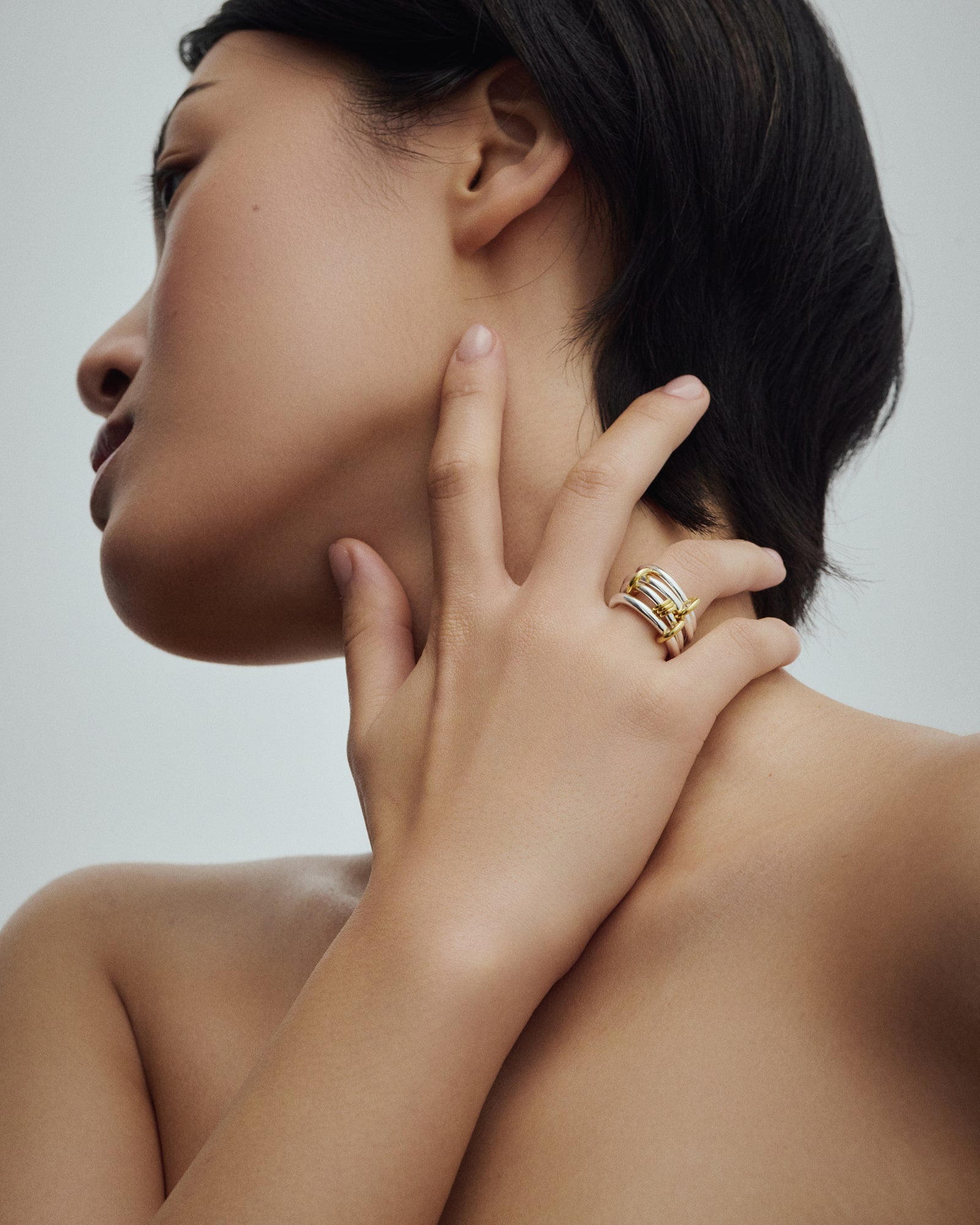 Female model wearing Éclis 4/mation ring in silver with gold details for COLD SKIN.