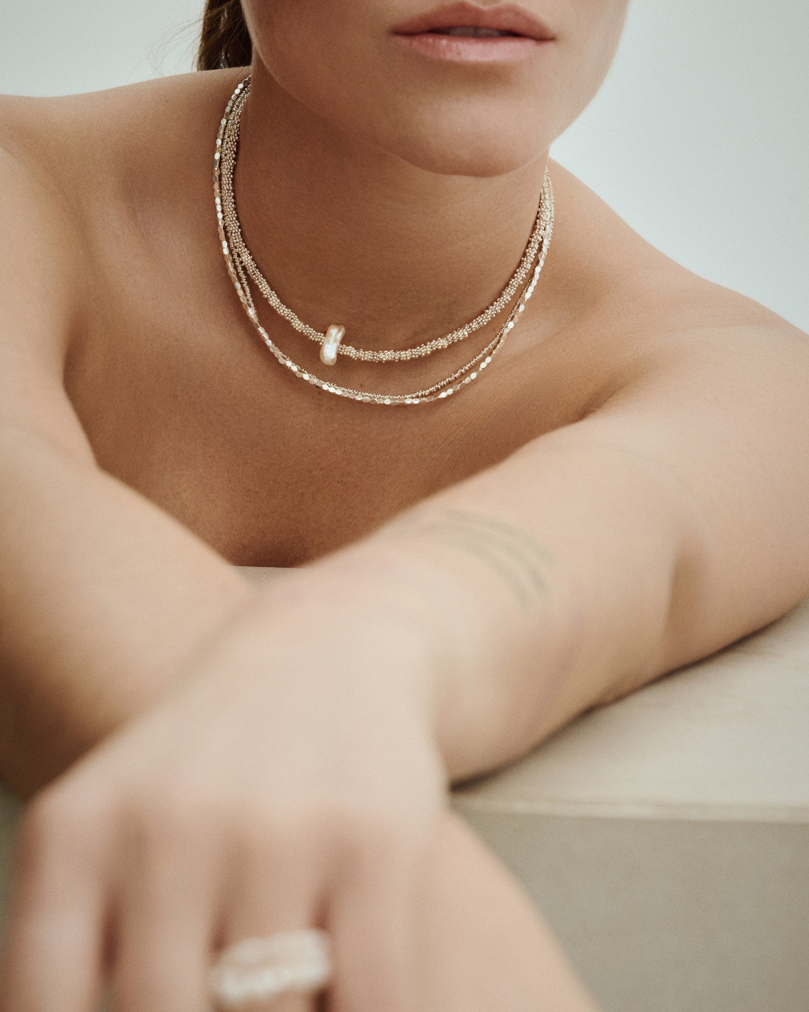 Model wearing Pearl Naked Reef Pearl Choker, Cubes Choker and Link Choker.