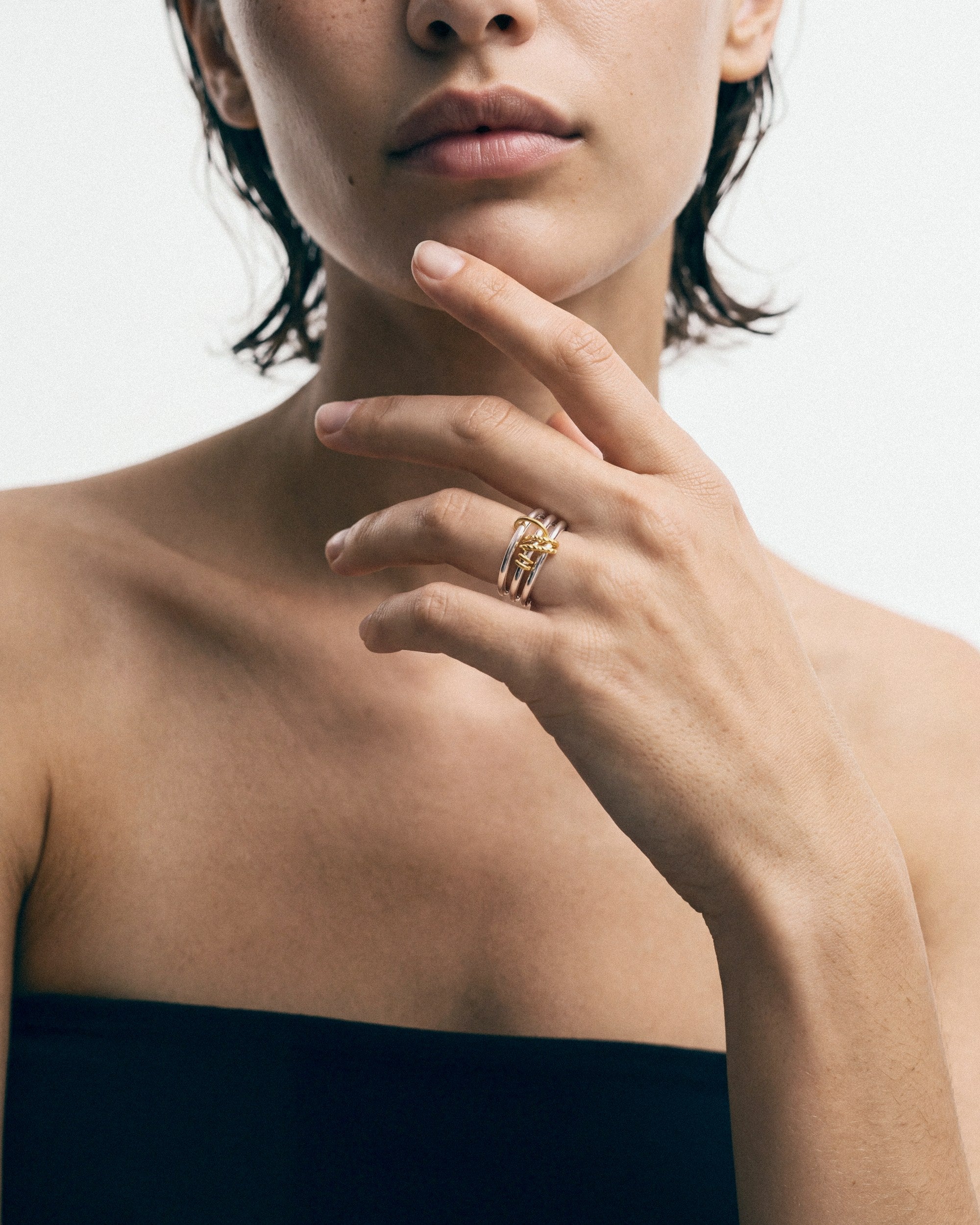 Éclis Triple Ring No. 2 in silver with gold detail, worn by a model — close-up, for COLD SKIN.