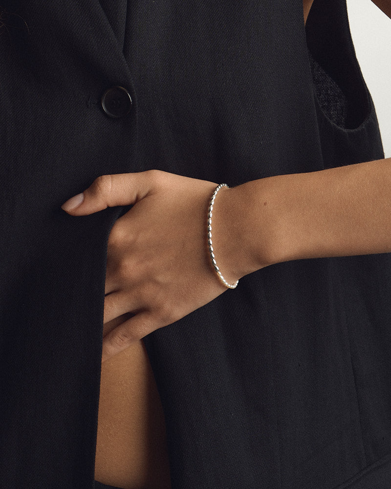 Female model wearing PEARL NAKED Lola Bracelet in Silver & Pearls, strand of small silver beads on the wrist, for COLD SKIN.
