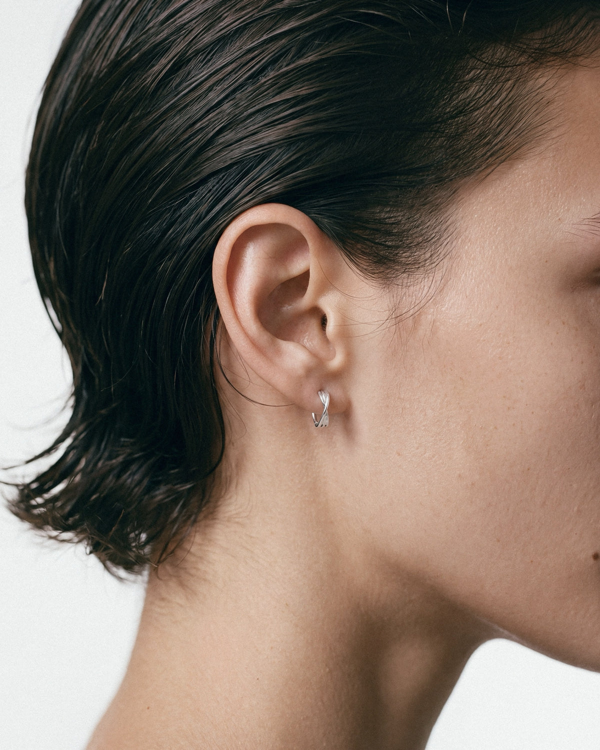 Baixa Eli Hoops in silver, worn by a model — close-up, for COLD SKIN.