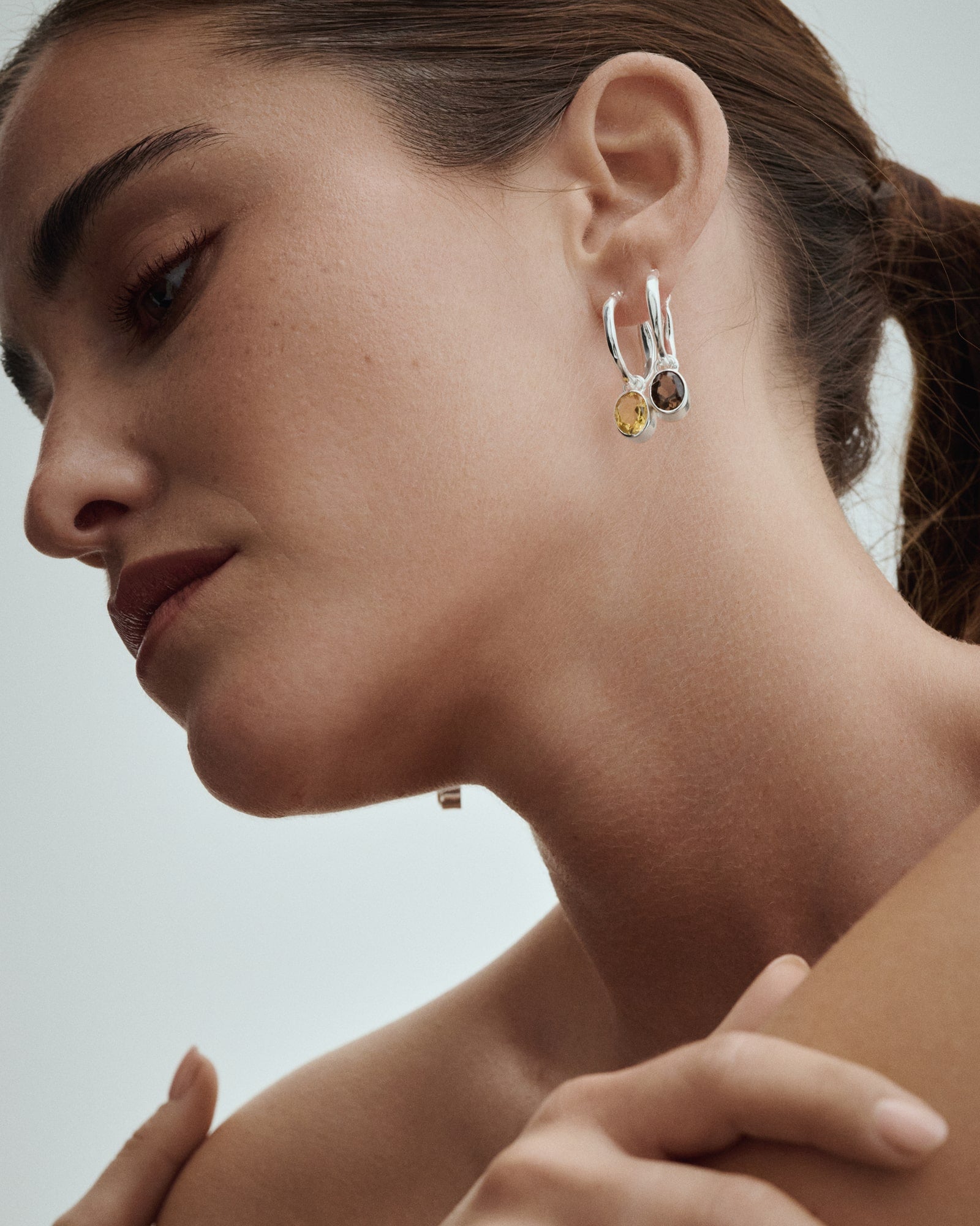 Weibliches Model trägt Arishi Ideal Hoops in Silber mit Rauchquarz und Citrin.