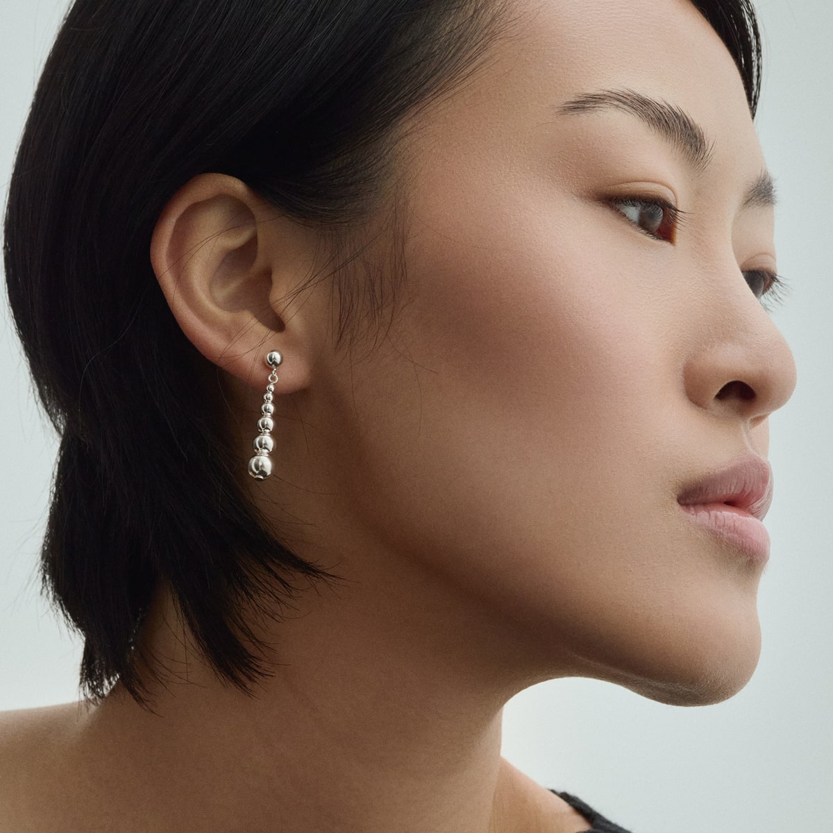 Female model wearing BAIXA Juno Earrings in silver for COLD SKIN.