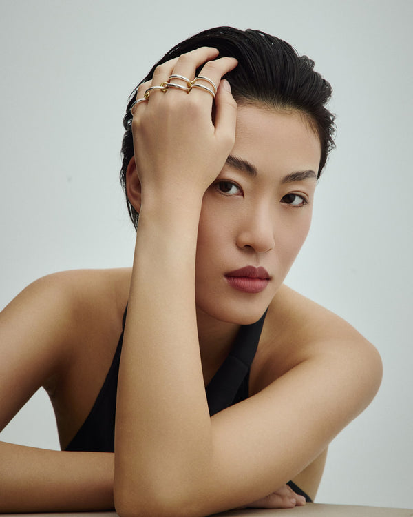 Female model wearing Éclis 4mation ring in silver with gold details.