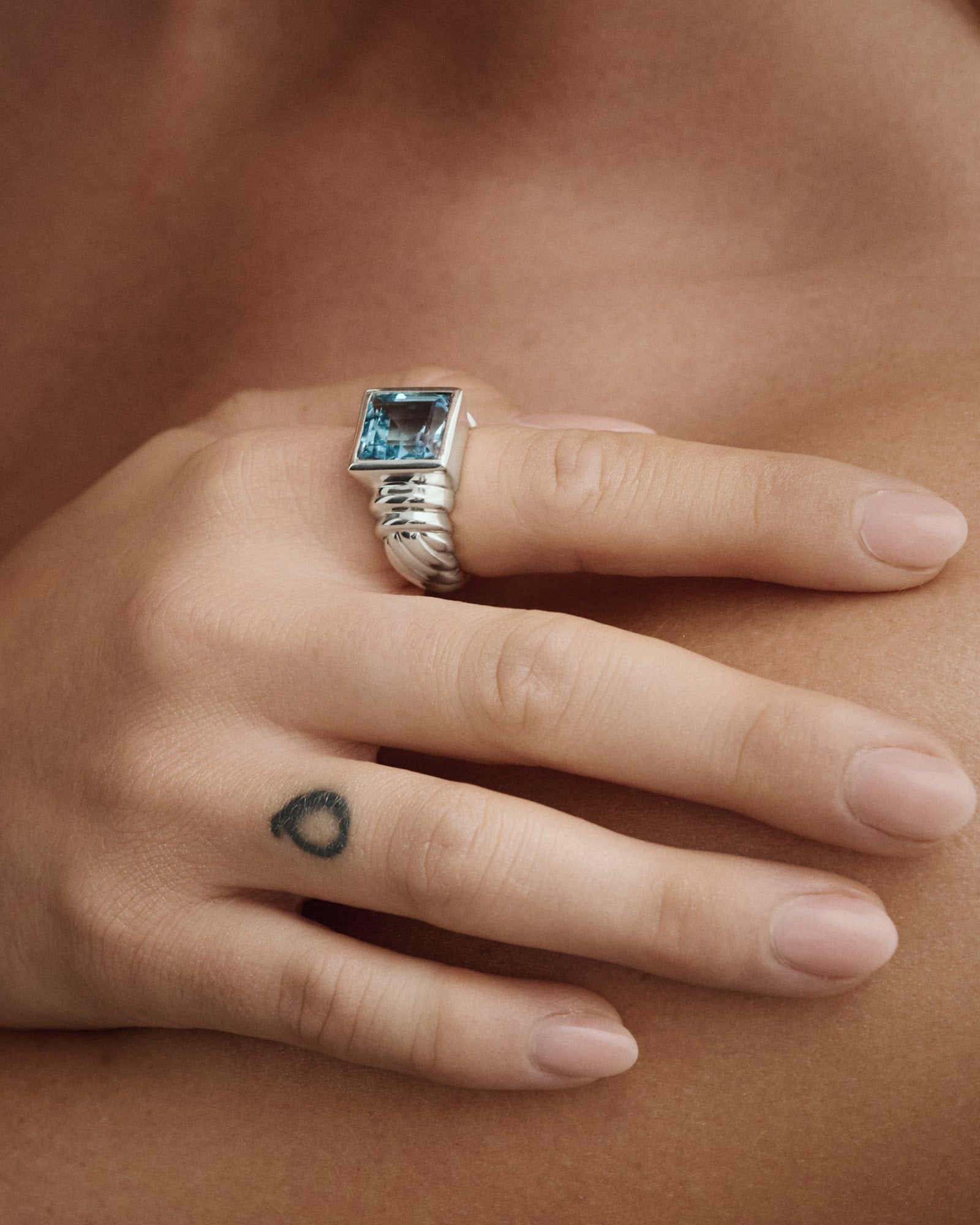 Female model wearing Èclis Blue Rebel Ring in silver for COLD SKIN.