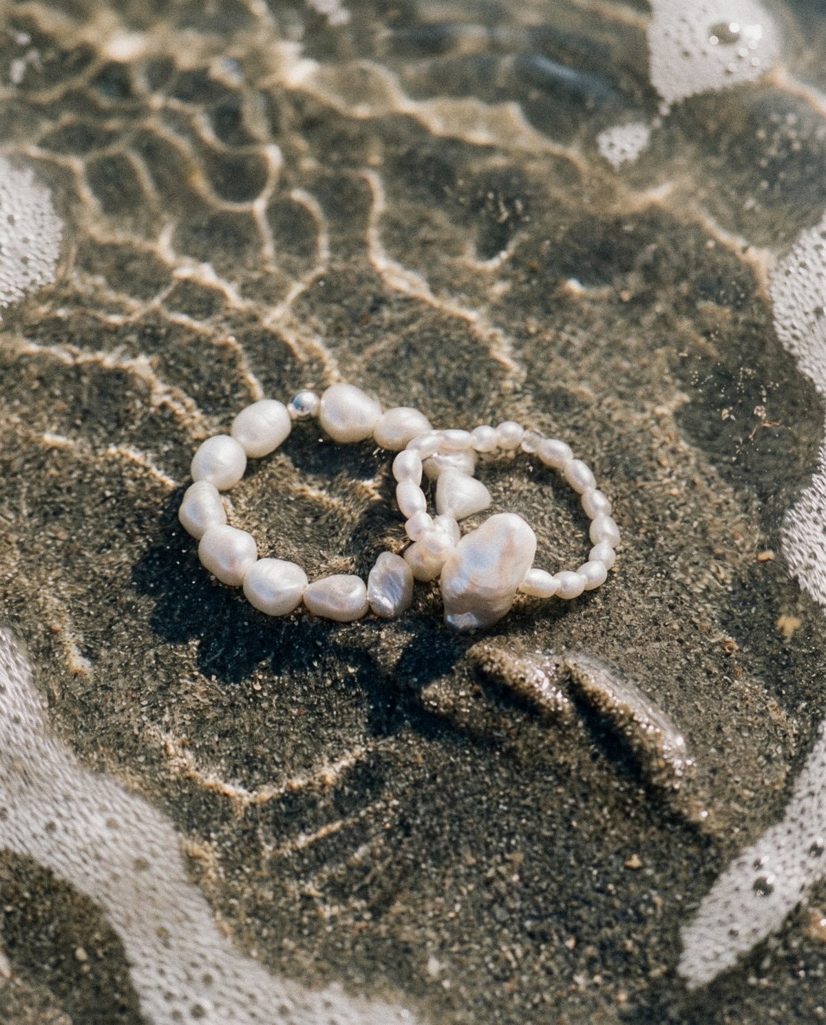 Close-up of the Pearl Naked Big Rice and August Ring under the water, photographed for COLD SKIN