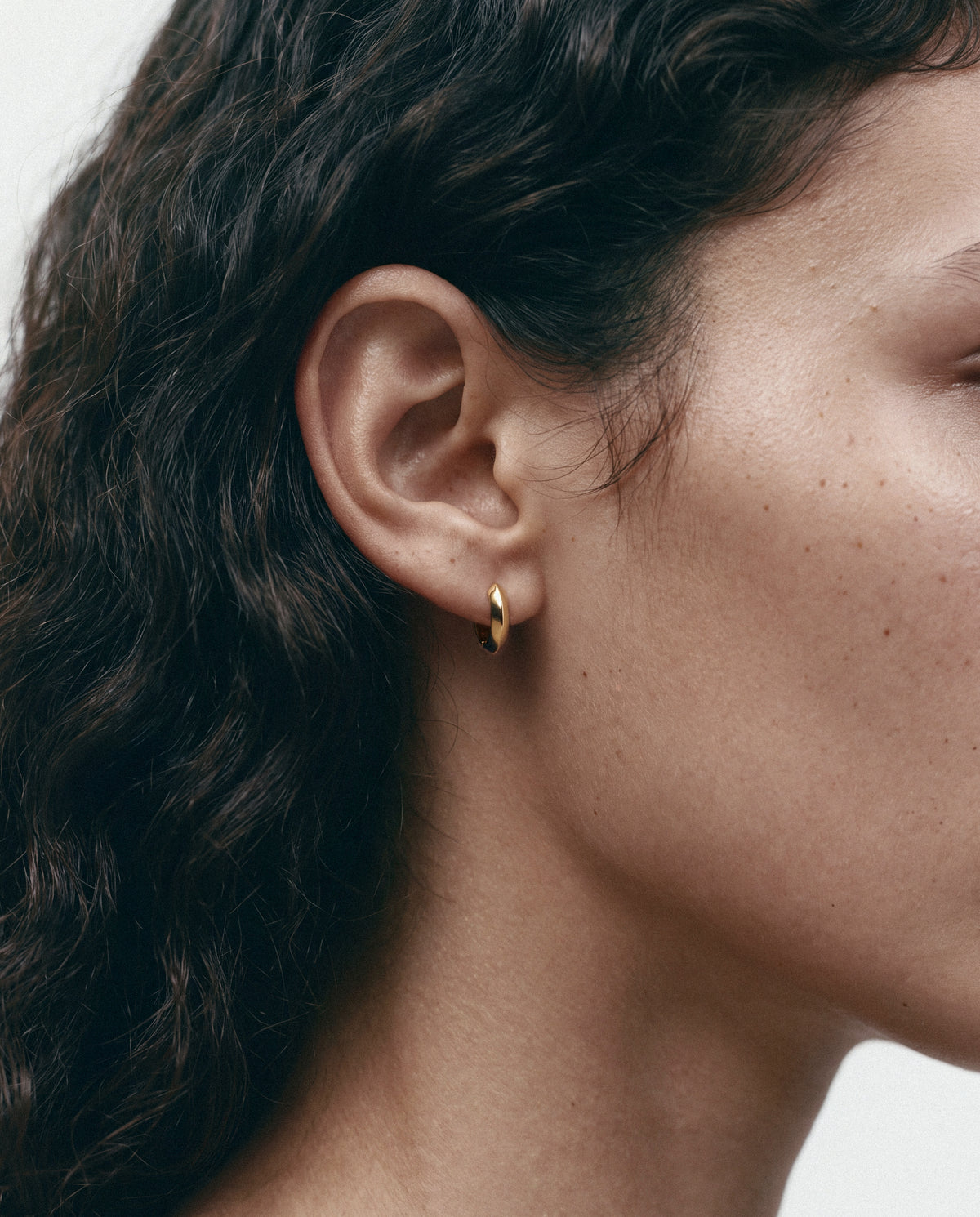 Close-up of the Mini Anchor Hoops - Gold, worn