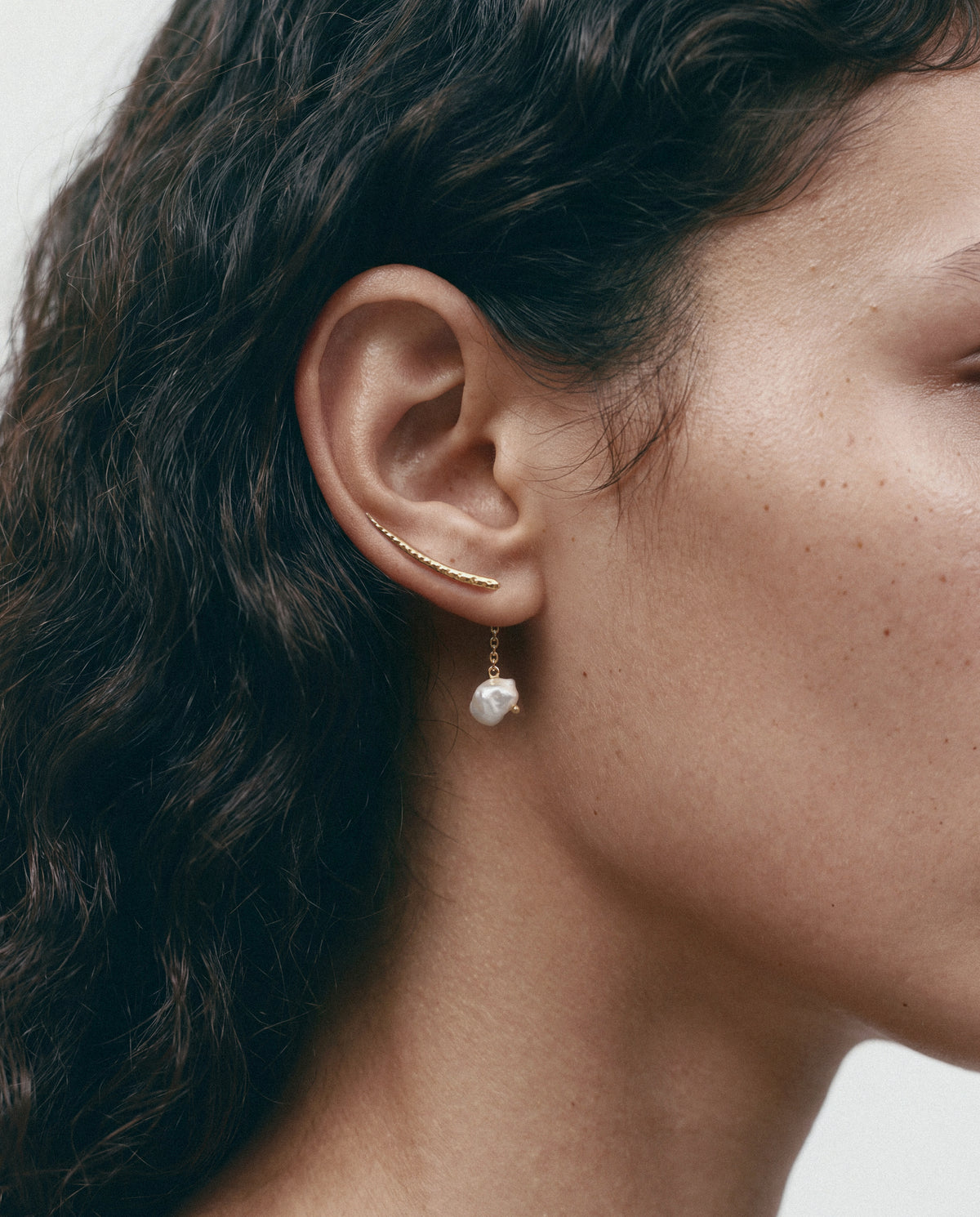Close-up of the Sumbawa Ear Cuff - Gold, worn