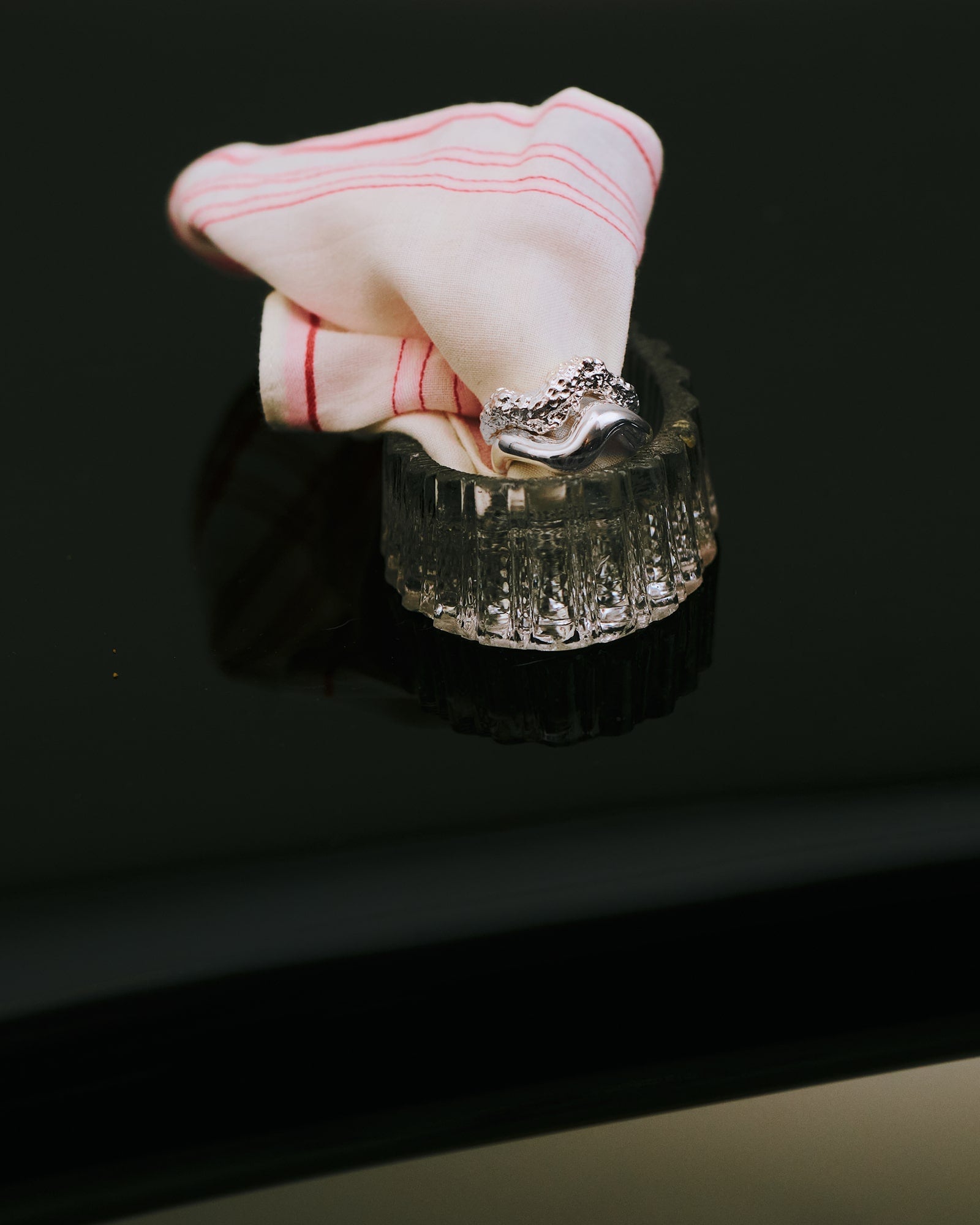 Louis Abel Aurea Polished Thin Ring and Louis Abel Aurea Thin Ring in a glass on a table.