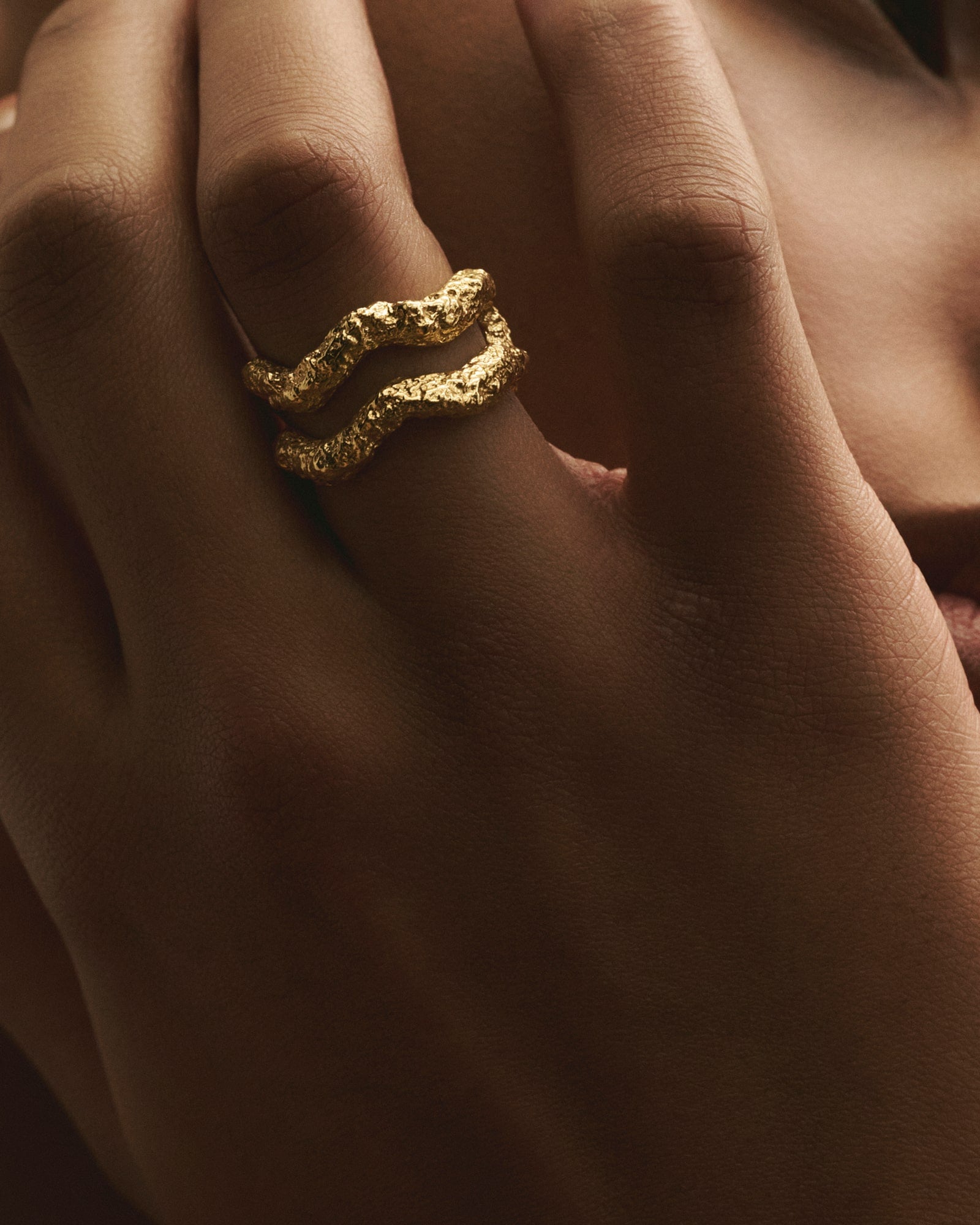 Close-up of women wearing Louis Abel Aurea Twin Ring in gold.