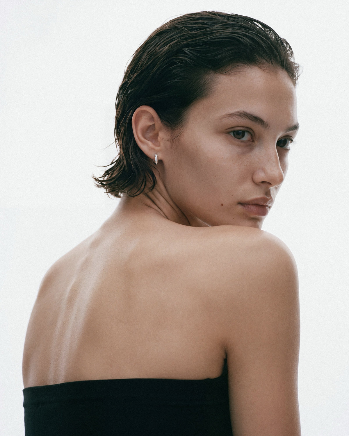SAGA Mini Anchor Hoops in Silver, worn by a model, for COLD SKIN.