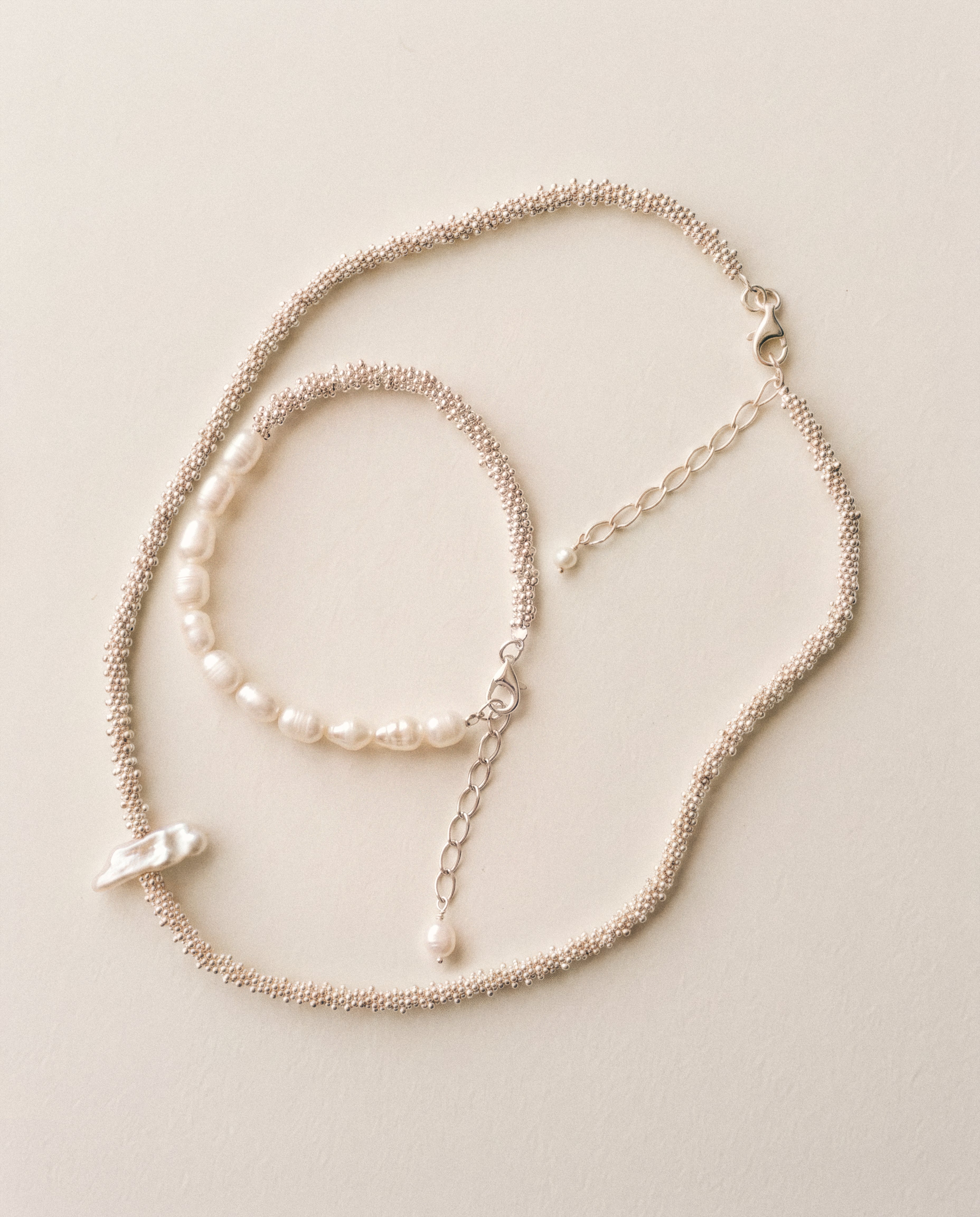 Close-up of Pearl Naked Reef Pearl Choker and Calypso Bracelet in silver.